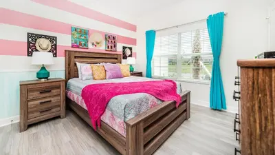 a bedroom with a bed with pink and blue walls at 4951 Windermere in Kissimmee