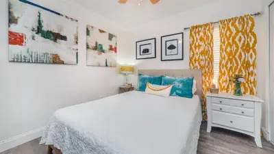 a bedroom with a white bed and some paintings at 2787 Lido Key in Kissimmee
