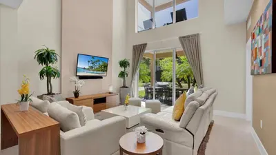 a living room with white furniture and a large window at 7646 Recife in Kissimmee