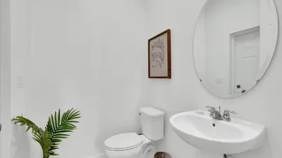 a bathroom with a toilet and a sink and a mirror at 2147 Cooper Bell in Kissimmee