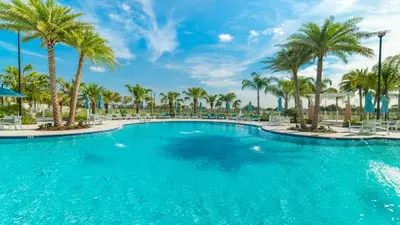 a large pool with palm trees and chairs at 2147 Cooper Bell in Kissimmee