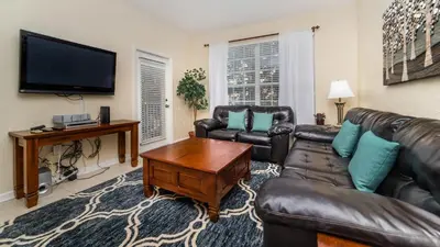 a living room with leather furniture and a flat screen tv at 7650 Comrow #204 in Kissimmee