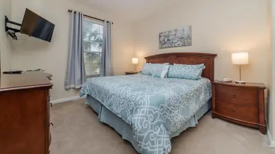 a bedroom with a bed and a tv and a window at 7650 Comrow #204 in Kissimmee