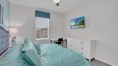 a white bedroom with a bed and a white dresser at 1840 Caribbean View in Kissimmee
