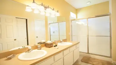 a bathroom with two sinks and a large mirror at 7713 Comrow in Kissimmee