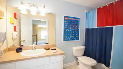 a bathroom with a toilet and a sink and a mirror at 7713 Comrow in Kissimmee