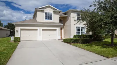 a house with two garage doors in a yard at 7713 Comrow in Kissimmee