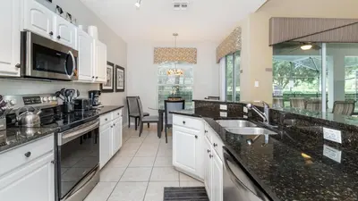 a large kitchen with black counter tops and appliances at 7713 Comrow in Kissimmee