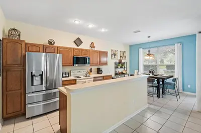 a kitchen with a stainless steel refrigerator and a table at 7719 Comrow in Kissimmee