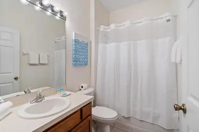 a white bathroom with a sink and a toilet at 7719 Comrow in Kissimmee