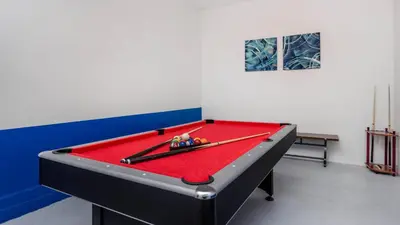 a room with a pool table with two cues on it at 4741 Kings Castle C in Kissimmee