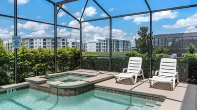 a swimming pool with two chairs and a building at 4741 Kings Castle C in Kissimmee
