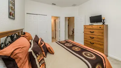 a bedroom with a bed and a dresser with a television at 7730 Comrow in Kissimmee
