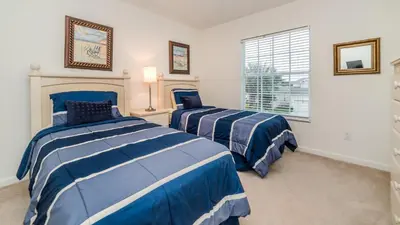 two beds in a room with blue and white stripes at 7730 Comrow in Kissimmee