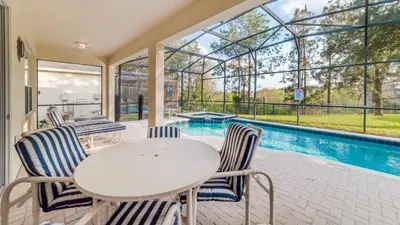 a patio with a table and chairs and a swimming pool at 7730 Comrow in Kissimmee