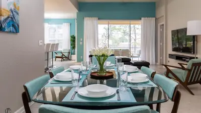 a dining room with a glass table and chairs at 7739 Comrow in Kissimmee