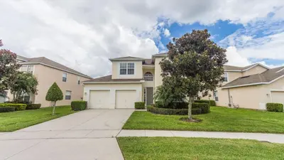 a large house with a driveway and grass at 2633 Daulby in Kissimmee