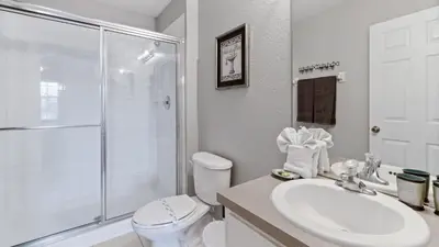 a bathroom with a toilet and a sink and a shower at 2644 Daulby in Kissimmee