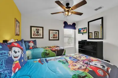 a bedroom with a bed with a mickey mouse bedspread at 7756 Grassendale in Kissimmee