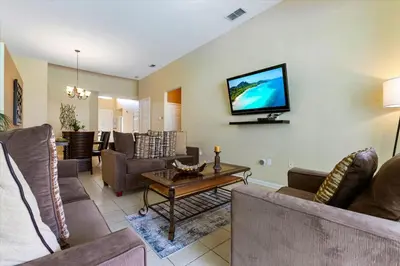 a living room with couches and a tv on the wall at 2678 Manesty in Kissimmee