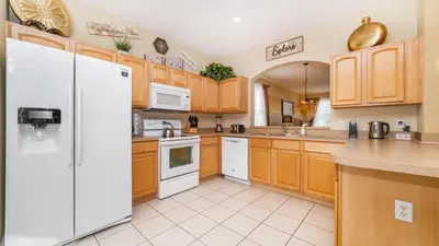 a kitchen with wooden cabinets and a white refrigerator at 2696 Manesty in Kissimmee