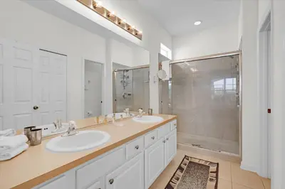 a white bathroom with two sinks and a shower at 2702 Manesty in Kissimmee