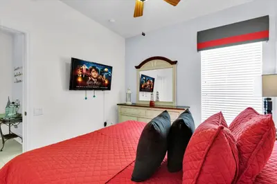 a bedroom with a red bed and a mirror at 2702 Manesty in Kissimmee