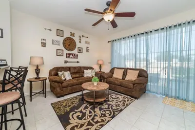 a living room with two couches and a ceiling fan at 2505 Maneshaw in Kissimmee