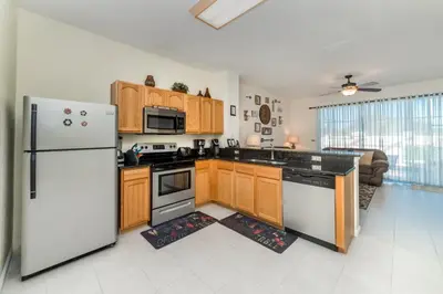 a kitchen with wooden cabinets and a white refrigerator at 2505 Maneshaw in Kissimmee