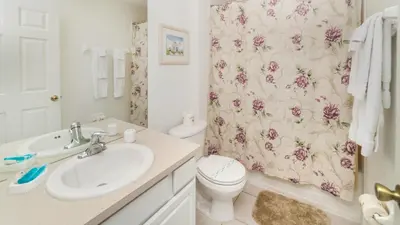 a bathroom with a sink and a toilet and a shower curtain at 7652 Otterspool in Kissimmee