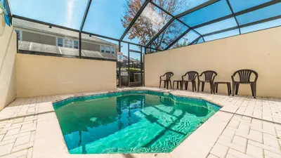 a swimming pool with chairs and a table at 7678 Otterspool in Kissimmee