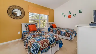 a bedroom with two beds and a mirror at 7678 Otterspool in Kissimmee
