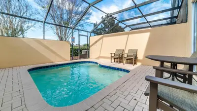 a swimming pool in a building with a table and chairs at 2508 Renshaw in Kissimmee