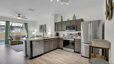 a kitchen with stainless steel appliances and a living room at 7679 Sir Kaufman in Kissimmee