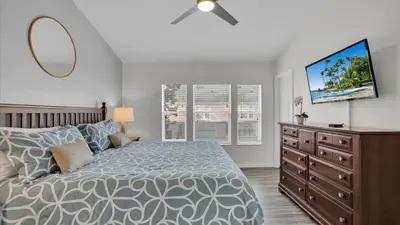 a bedroom with a bed and a dresser with a tv at 7679 Sir Kaufman in Kissimmee
