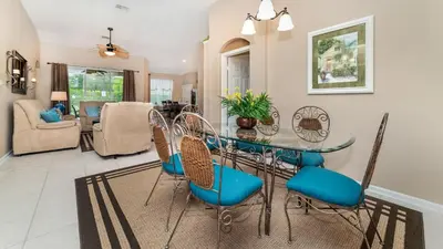 a dining room with a glass table and chairs at 8104 Fan Palm in Kissimmee