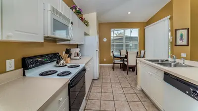 a kitchen with a sink and a stove top oven at 8147 Fan Palm in Kissimmee