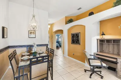 a dining room with a table and chairs and a piano at 8157 Fan Palm in Kissimmee