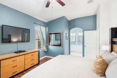 a bedroom with blue walls and a bed and a tv at 8157 Fan Palm in Kissimmee