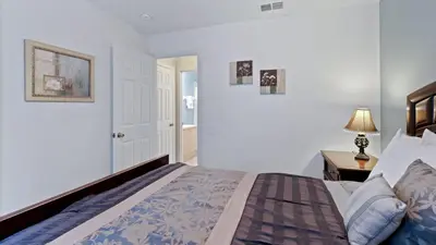 a bedroom with a bed and a lamp on a table at 8159 Fan Palm in Kissimmee