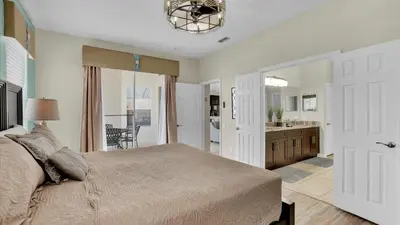 a bedroom with a large bed and a bathroom at 8176 Fan Palm in Kissimmee