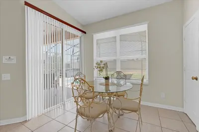 a dining room with a table and chairs and a window at 8190 Fan Palm in Kissimmee