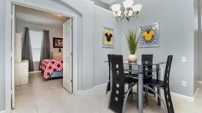a dining room with a table and chairs and a bedroom at 8208 Fan Palm in Kissimmee