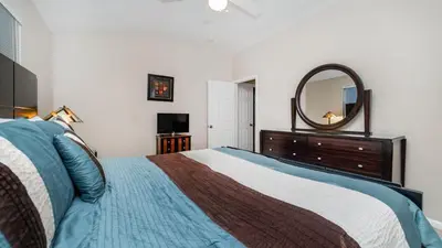 a bedroom with a bed with a dresser and a mirror at 8008 King Palm in Kissimmee