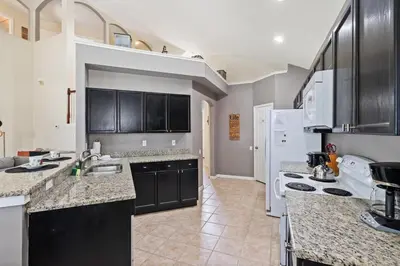 a kitchen with black cabinets and a white appliances at 8038 King Palm in Kissimmee