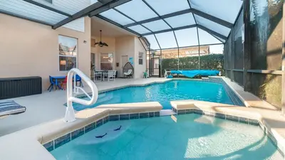 an indoor swimming pool with a pool slide in a house at 8136 Sun Palm in Kissimmee