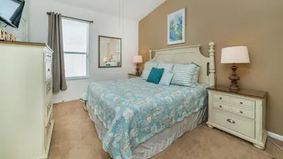 a bedroom with a bed and a dresser and a window at 8137 Sun Palm in Kissimmee