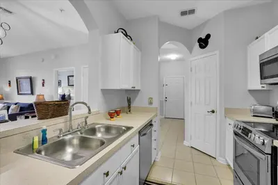 a kitchen with white cabinets and a sink at 2302 Silver Palm # 103 in Kissimmee