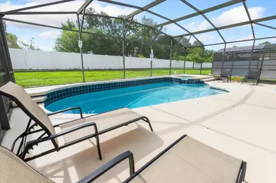 a swimming pool with a pergola and chairs at 2209 Wyndham Palms in Kissimmee