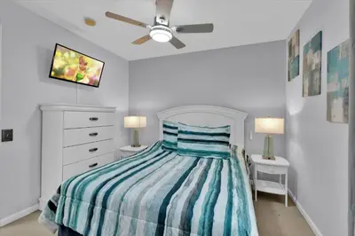 a bedroom with a bed with a striped comforter at 2244 Wyndham Palms in Kissimmee